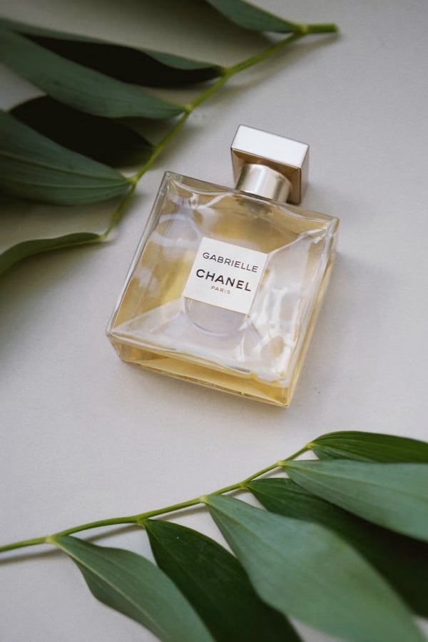 a bottle of Gabrielle Chanel Perfume next to decorative leaves