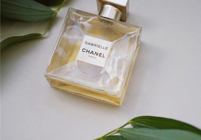 a bottle of Gabrielle Chanel Perfume next to decorative leaves